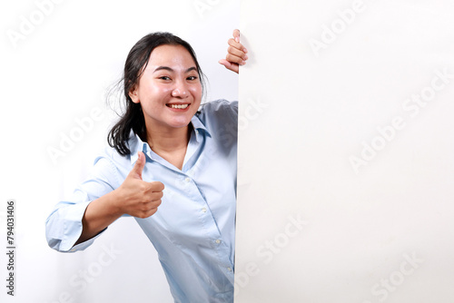 Happy smiling beautiful young woman showing blank signboard or copyspace for slogan or text while making thumbs up gesture, isolated over white background