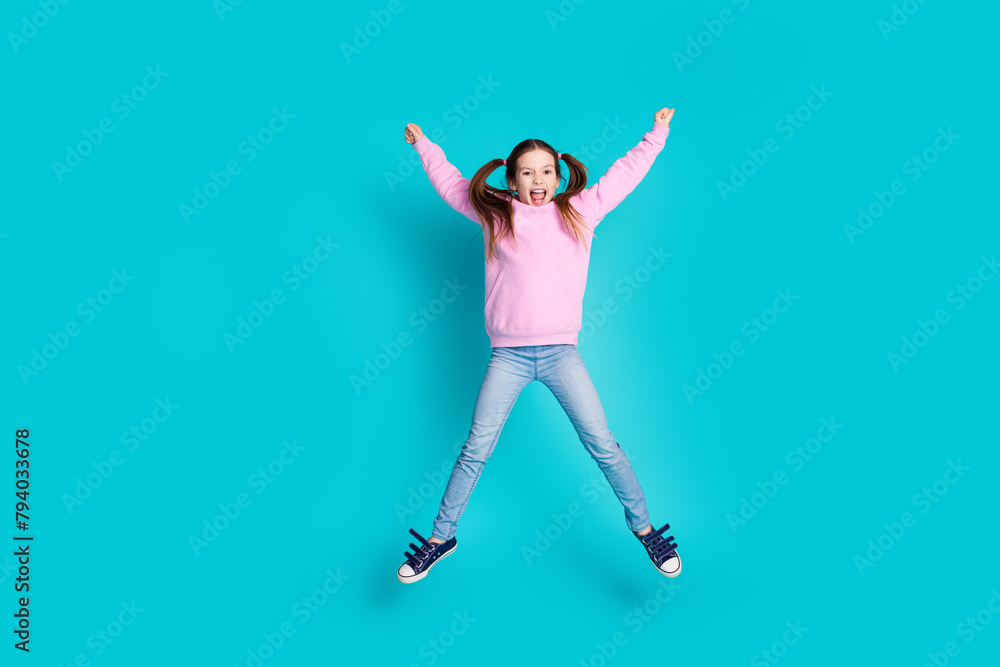 Full body photo of cute little girl jump star pose dressed stylish pink clothes isolated on aquamarine color background