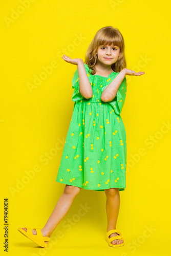 What. Why. Blonde school girl raising hands in indignant expression, asking why, what reason of failure demonstrating disbelief irritation by troubles. Preteen child kid on yellow background. Vertical