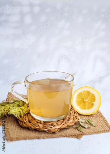 Glass cup with Mursala tea and lemon  on a wooden background  photo
