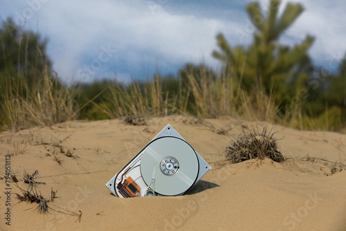 brocken computer hard disk in sand