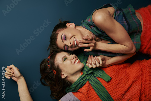 Two young women in comfortable attire, sharing a moment of connection by laying on top of each other.