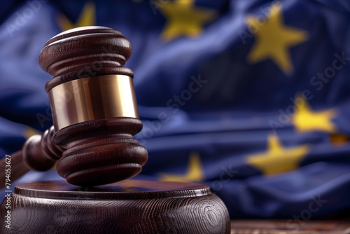 close-up focusing on the texture and craftsmanship of a judge's gavel, set against the backdrop of the EU flag, symbolizing the application of European laws and regulations in judi photo