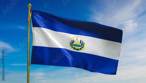 Die Fahne von El Salvador flattert im Wind, isoliert gegen blauer Himmel photo