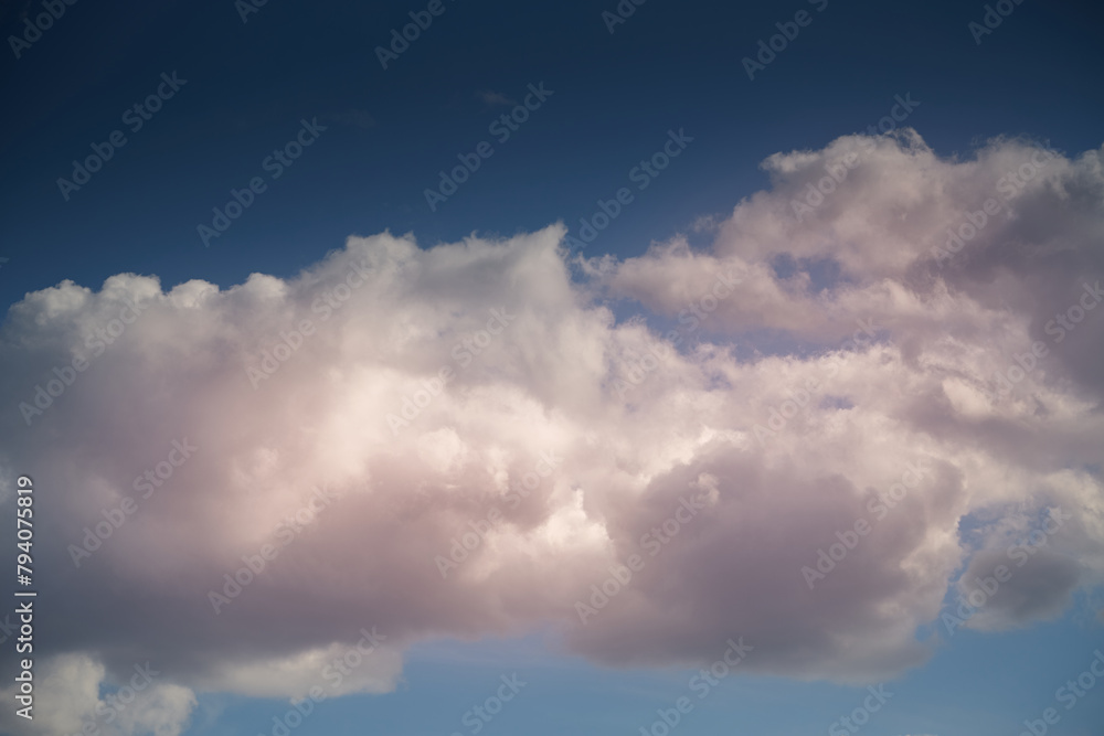 Evening sunlight on white clouds in the sky, sky landscape with evening light and white clouds