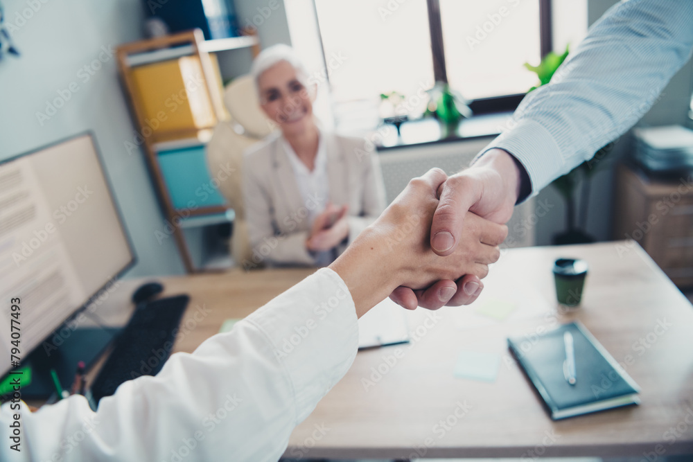 Cropped photo of two employees mature boss woman shake hands office team meeting discussion colleagues working together in workstation Cropped photo of two employees mature boss woman shake hands office team meeting discussion colleagues working together in workstation