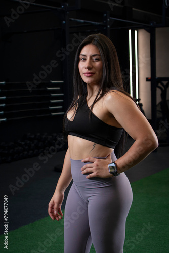 Portrait of a female athlete wearing sportswear standing in the gym looking at camera
