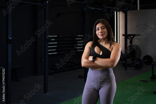 Mexican female athlete with arms crossed looks at camera smiling
