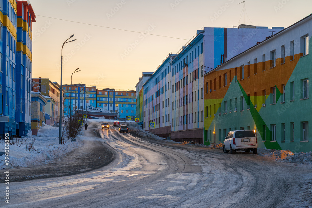View of the street and colorful multi-colored buildings in a well-maintained northern city. Travel to the Arctic and the Russian Far East. Anadyr city, Chukotka, Russia. Evening city landscape.