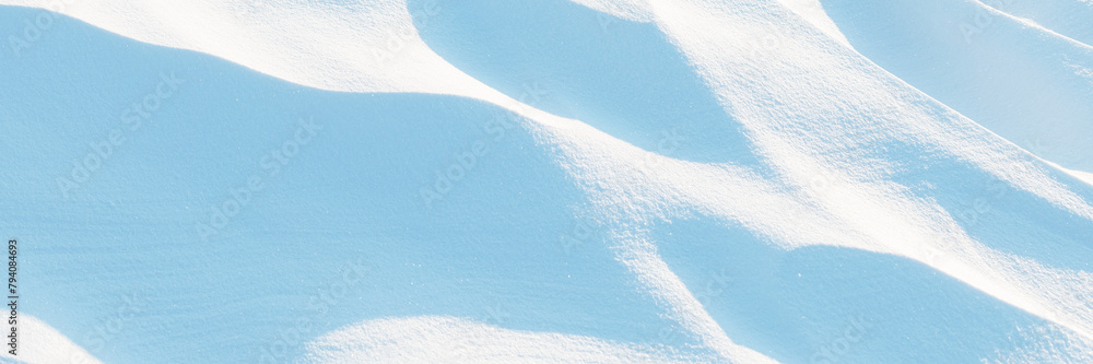 Snow texture. Wind sculpted patterns on snow surface. Wind in the tundra and in the mountains on the surface of the snow sculpts patterns and ridges (sastrugi). Arctic, Polar region. Winter background Snow texture. Wind sculpted patterns on snow surface. Wind in the tundra and in the mountains on the surface of the snow sculpts patterns and ridges (sastrugi). Arctic, Polar region. Winter background
