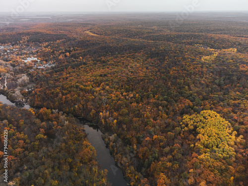 Aerial autumn forest on river hills, colorful autumnal countryside