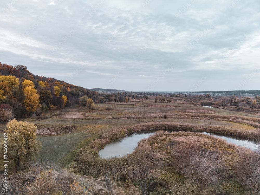 Aerial view on autumn rural scenery in Ukraine with cloudy grey sky, fields and forest
