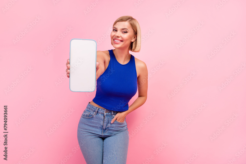 Portrait of nice girl demonstrate empty space smart phone screen wear blue top isolated on pink color background Portrait of nice girl demonstrate empty space smart phone screen wear blue top isolated on pink color background