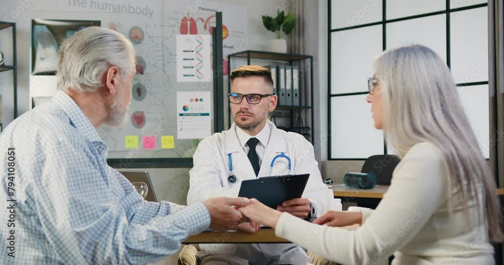 Senior man and woman couple visiting their family doctor in modern clinic. Medicine and healthcare concept. Senior man and woman couple visiting their family doctor in modern clinic. Medicine and healthcare concept.