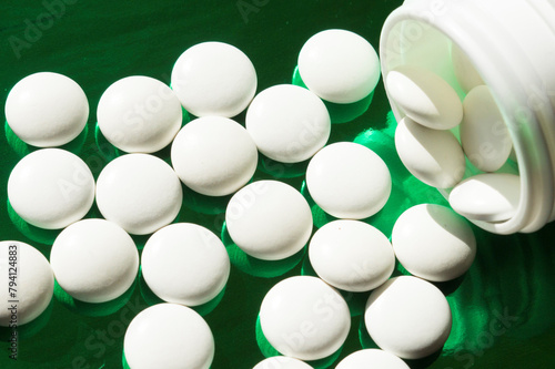 white pills on a green shiny background