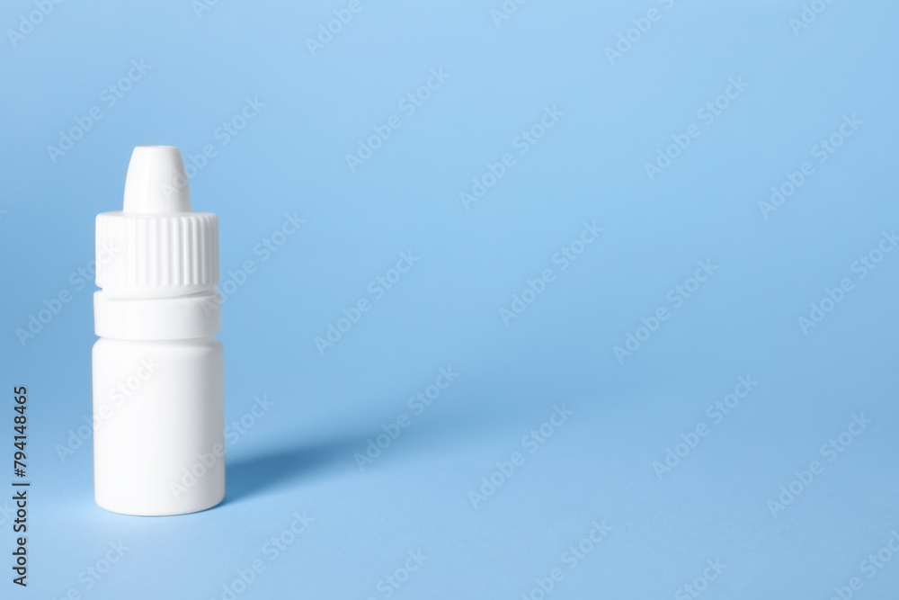 Bottle of medical drops on light blue background, space for text Bottle of medical drops on light blue background, space for text