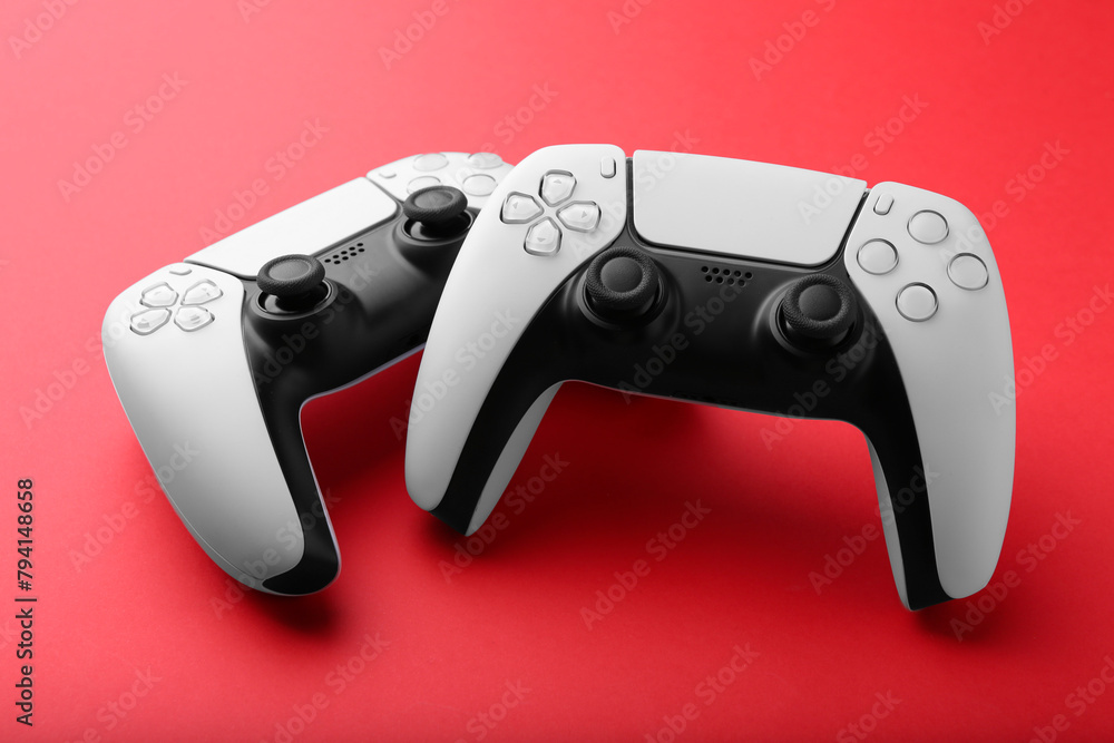 Two wireless game controllers on red background Two wireless game controllers on red background