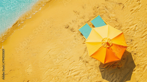 Aerial view of two sun loungers under a vibrant umbrella by the sea photo