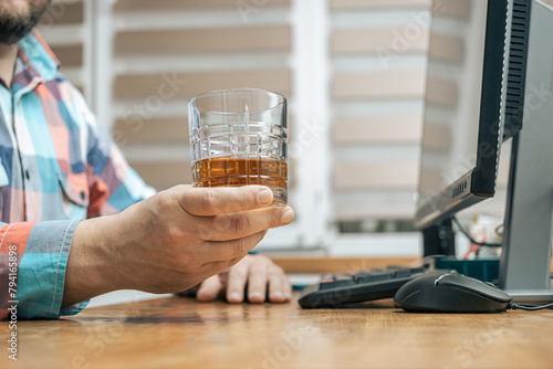 Quadro su tela Drunk and frustrated man in the office while working with pc, sitting at the wor