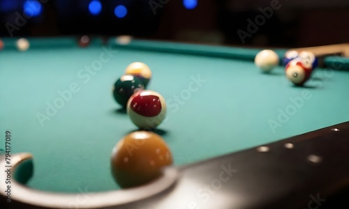 A pool table with billiard balls scattered on the green felt surface, with a blurred background