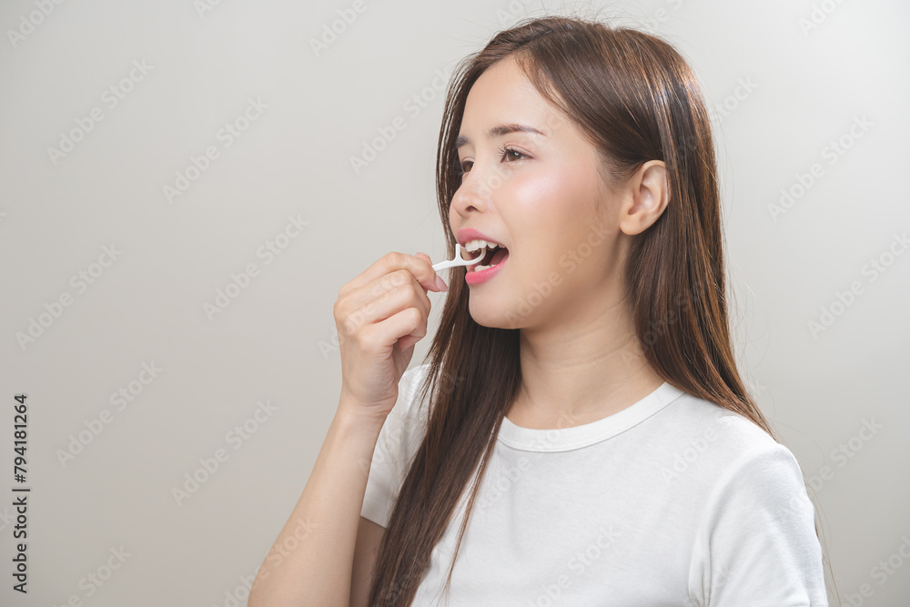 Flossing teeth, dental care hygiene, asian young woman flossing teeth with dental floss pick, smile happy with perfect white teeth, using tooth floss cleaning, healthy teeth isolated on background. Flossing teeth, dental care hygiene, asian young woman flossing teeth with dental floss pick, smile happy with perfect white teeth, using tooth floss cleaning, healthy teeth isolated on background.