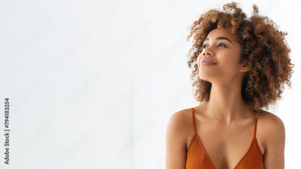 Afro woman wearing orange v-neck body smile looking up isolated on gray Afro woman wearing orange v-neck body smile looking up isolated on gray