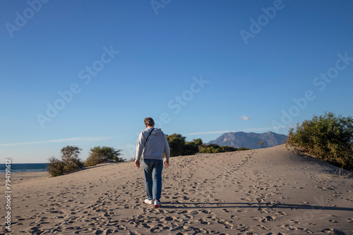 A man walks along the sand dunes alone