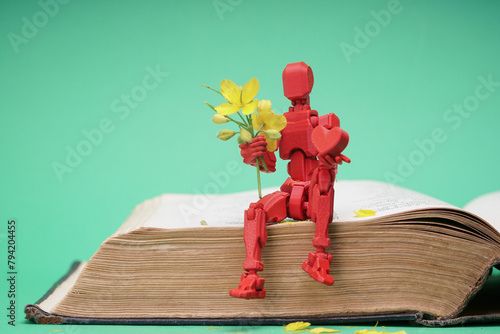 This photo shows a figure of a person sitting on an open book, holding a bouquet of flowers and a heart. This image can symbolize reading, learning or studying with love and tenderness. A figure sitti