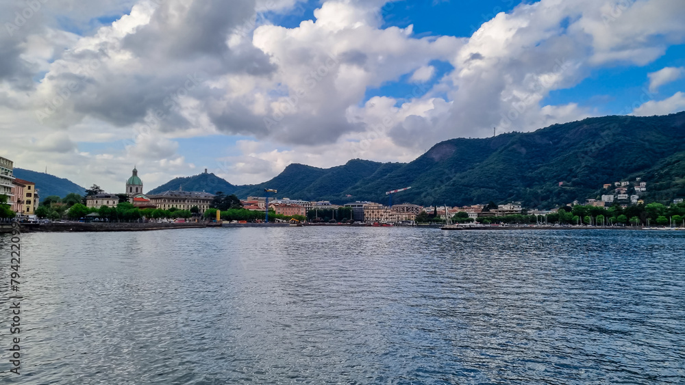 Panoramic view from a boat of city and lake of Como, Lomardy, Italy, Europe. Yachting on alpine mountain lake in the Italian Alps in summer. Living luxury life style, architecture and travel concept