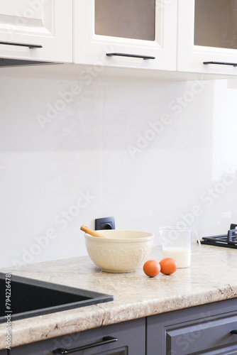 Home kitchen interiorBowl with dough, eggs and bowl of sugar on kitchen table in modern kitchen.