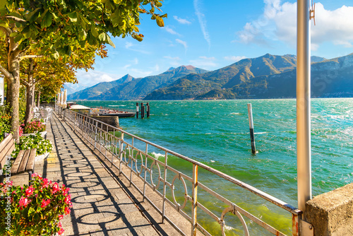The lakefront walking path on the shores of Lake Como at the small village of Tremezzo, inside the town comune of Tremezzina, Italy. photo