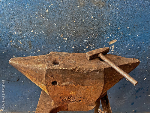 Used by blacksmiths for working metals. Old anvil and hammer in a forge.