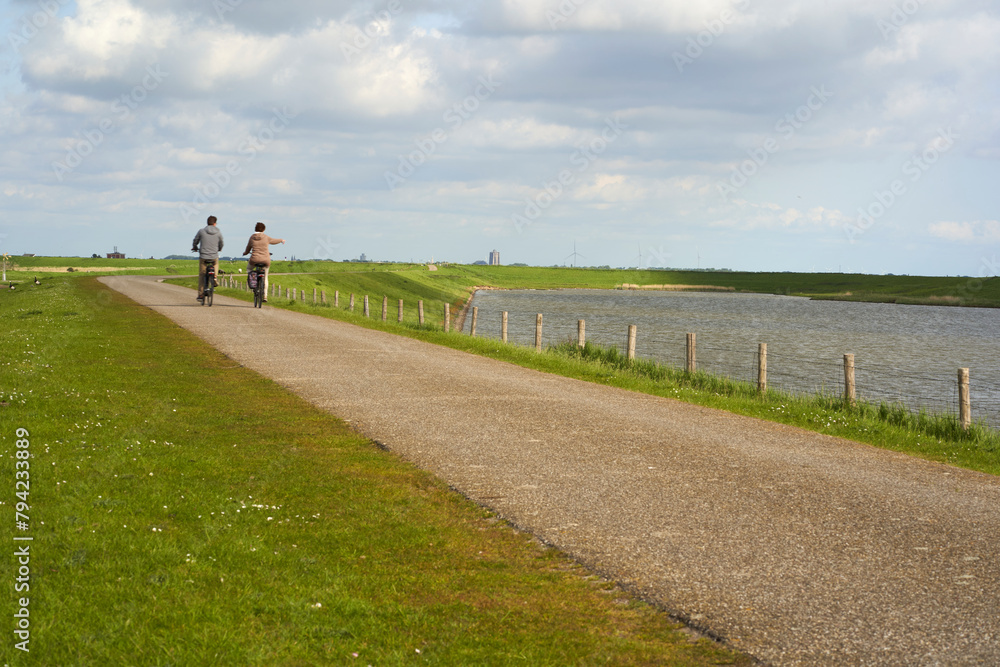 National Park in Holland. Landscape in spring on a sunny day. Cyclists on dam Netherlands, Zeeland, Oosterschelde.