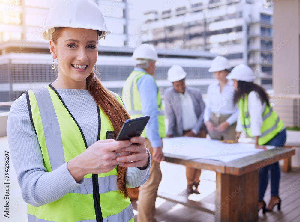 Fototapeta premium Happy woman, portrait and construction worker with smartphone, team and plans in city. Female engineer, smile and builders in meeting for planning, building and development in urban town for property
