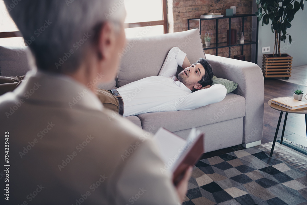Portrait of young man lay sofa speak visit consultation psychotherapist loft interior office indoors