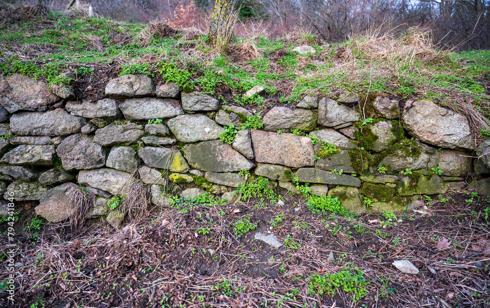 Old stone wall with green grass.