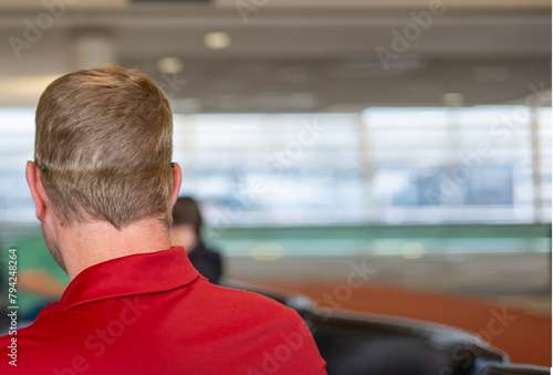 Selective focus on the back of an adult male with hat-hair caused by wearing a baseball cap.
