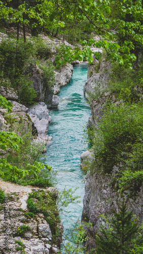 Turquoise Soča or Isonzo river winding through rugged rock formations, capturing the raw beauty and power of nature.