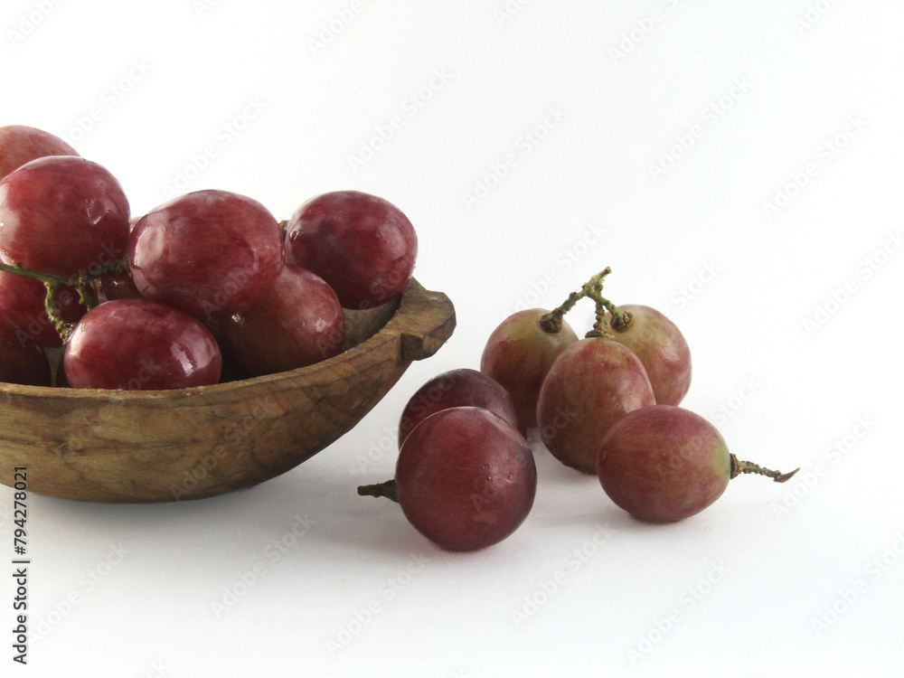 red grape in wooden bowl white background