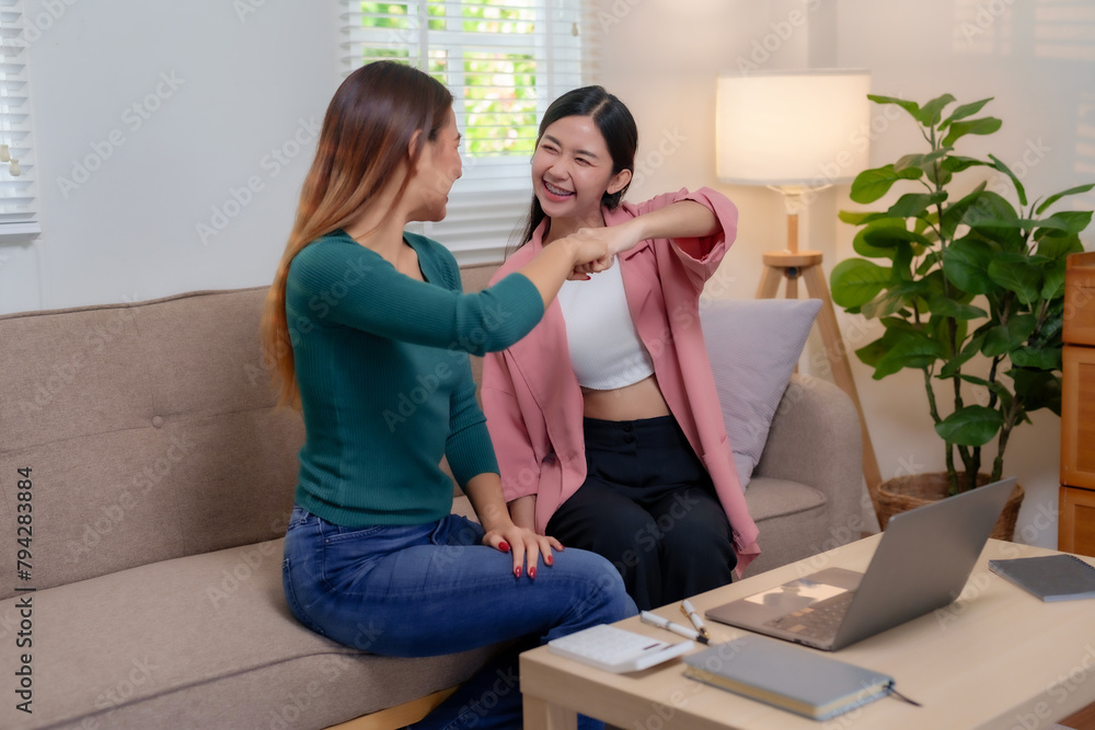 Two female colleagues sharing a fun moment in a cozy home office setting. Workplace camaraderie and joyful interaction concept. Two female colleagues sharing a fun moment in a cozy home office setting. Workplace camaraderie and joyful interaction concept.