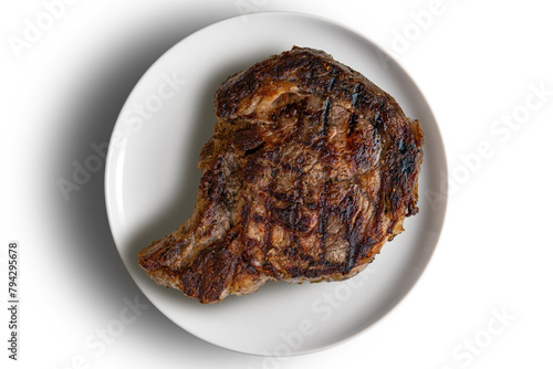 Whole rib eye beef on a round white plate