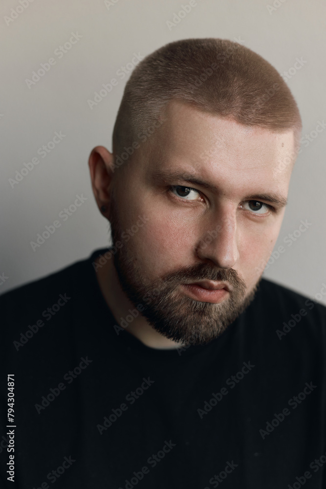 Portraits of a Millennial guy with a short haircut and beard, earrings in his ears Portraits of a Millennial guy with a short haircut and beard, earrings in his ears