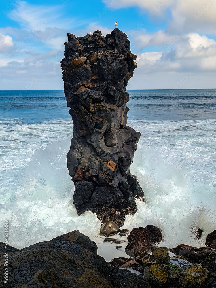 Fototapeta premium The rock pillar in the sea with rough waves at the Santa Barbara beach on San Miguel, Azores. 