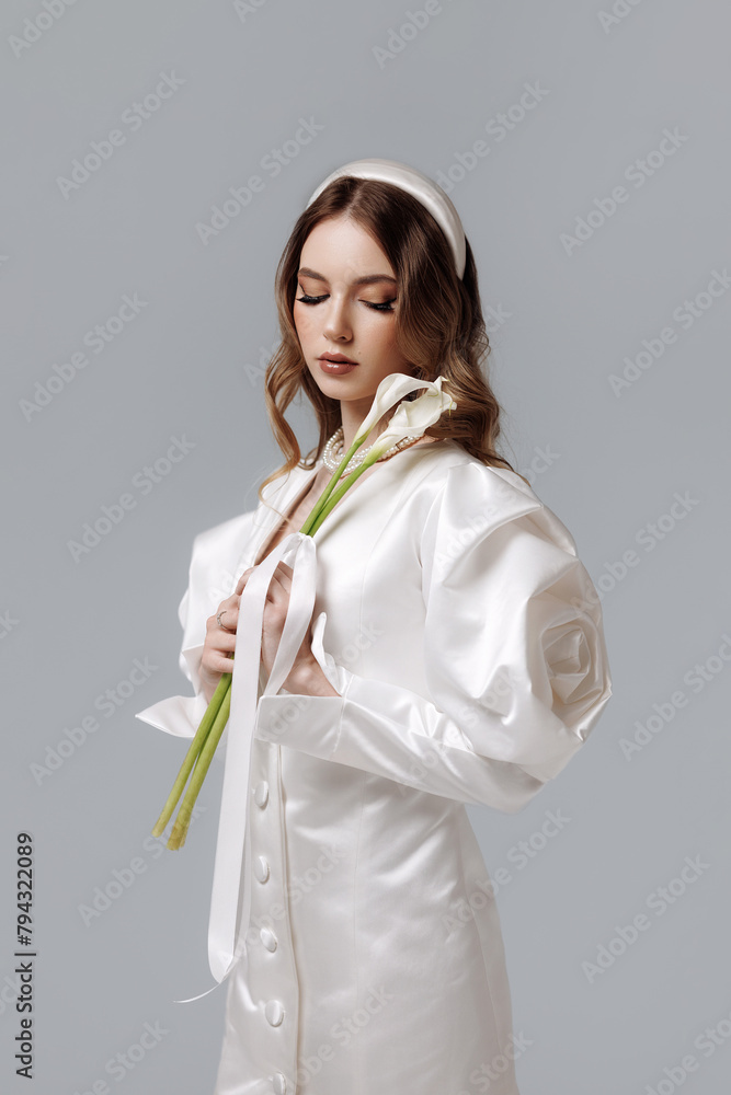 A woman in a white dress holding a flower. High quality photo A woman in a white dress holding a flower. High quality photo