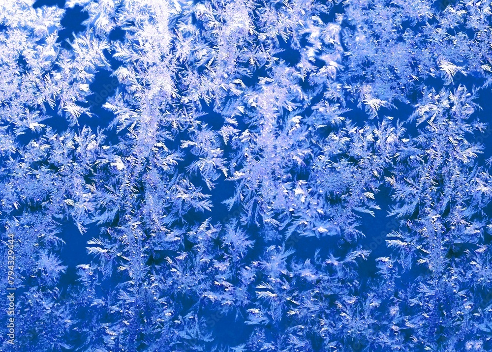 Frosted glass blue texture, winter window ice background. Frosty glass ice backdrop ultra-navy blue white colors. Frost bright lace pattern. Abstract grunge colorful cold background close-up or fond Frosted glass blue texture, winter window ice background. Frosty glass ice backdrop ultra-navy blue white colors. Frost bright lace pattern. Abstract grunge colorful cold background close-up or fond