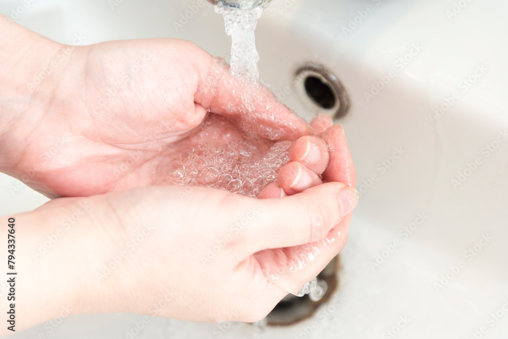 person washing hands in bathroom person washing hands in bathroom