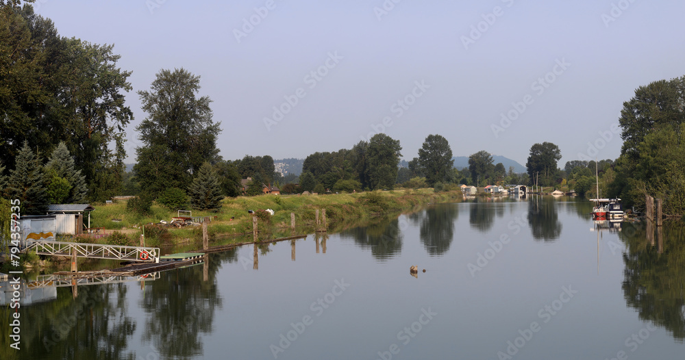 Tranquil river reflecting moored boats