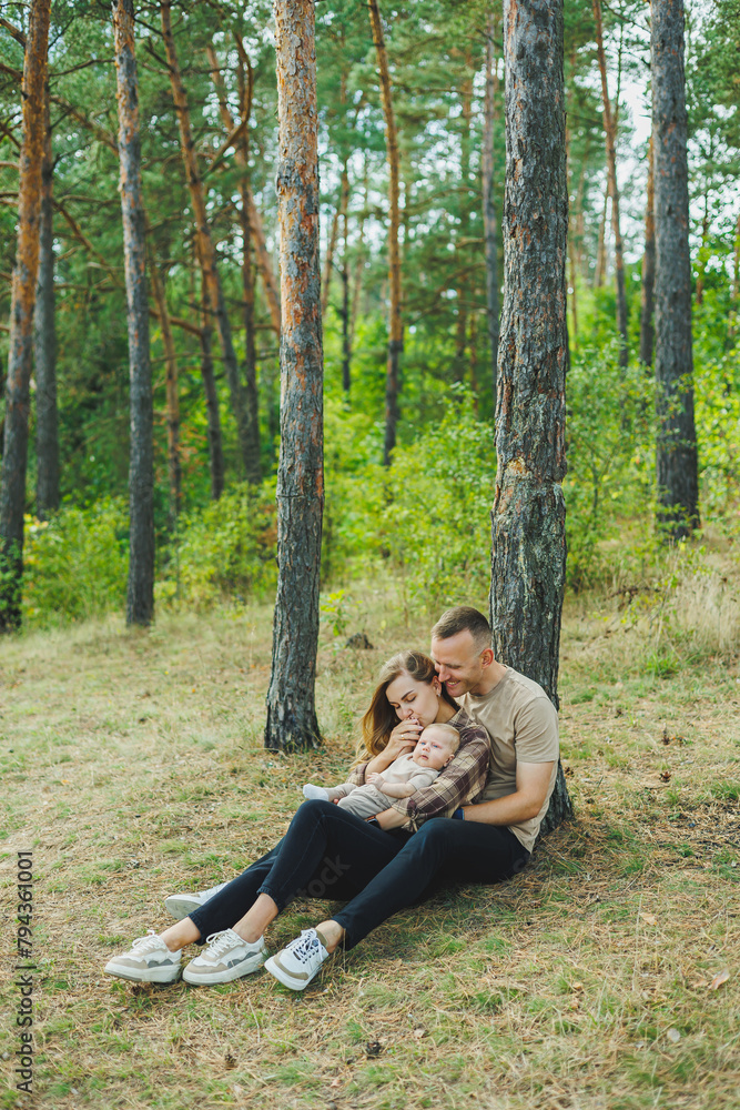 Happy family together: beautiful young parents walking with their newborn baby in the park on a sunny summer day. Happy family together: beautiful young parents walking with their newborn baby in the park on a sunny summer day.