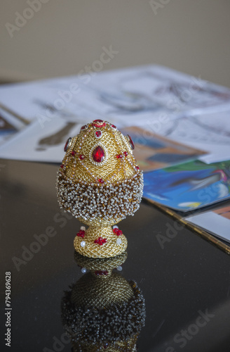 Decorative egg made of gold beads and glass stones