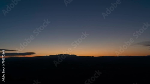 Full Sunrise over Auvergne mountains from Correze, with yellow bright sun, clear sky, sunrays